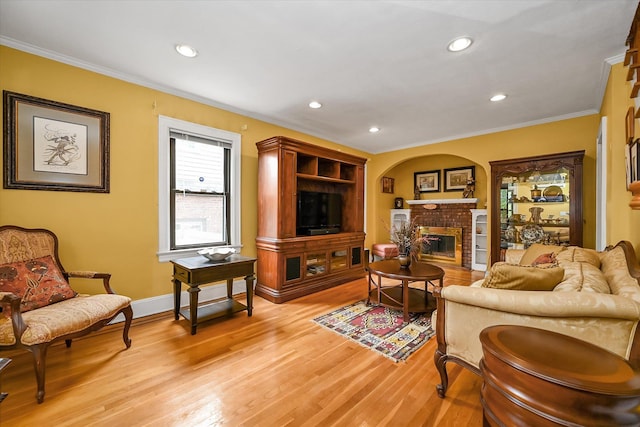 33-50 210th St, Bayside, NY 11361 - living area with ornamental molding, a brick fireplace, light wood finished floors, recessed lighting, and arched walkways