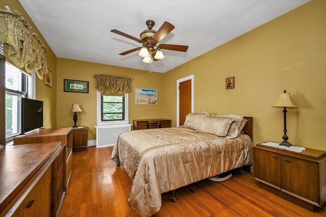 33-50 210th St, Bayside, NY 11361 - bedroom featuring radiator, wood finished floors, and ceiling fan
