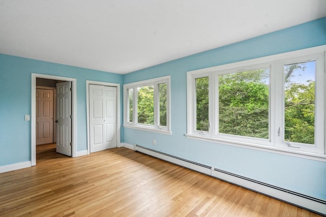 542 Montauk Hwy, Southampton, NY 11968 - unfurnished bedroom featuring a baseboard radiator, light wood-style floors, and a closet