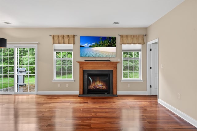 84 Jasmine Dr, Middletown, NY 10940 - unfurnished living room featuring wood finished floors, healthy amount of natural light, and a glass covered fireplace