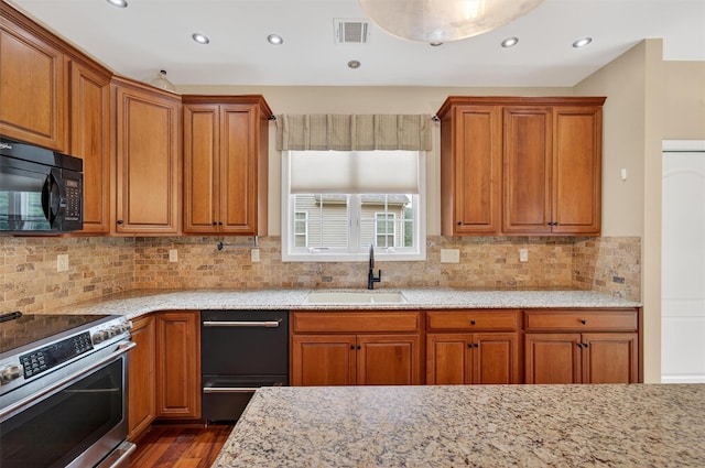 84 Jasmine Dr, Middletown, NY 10940 - kitchen featuring black appliances, light stone countertops, brown cabinetry, and recessed lighting
