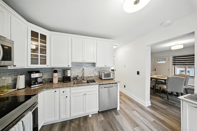 2 Woodland Way N, Ellenville, NY 12428 - kitchen featuring appliances with stainless steel finishes, light wood-style flooring, tasteful backsplash, and white cabinetry