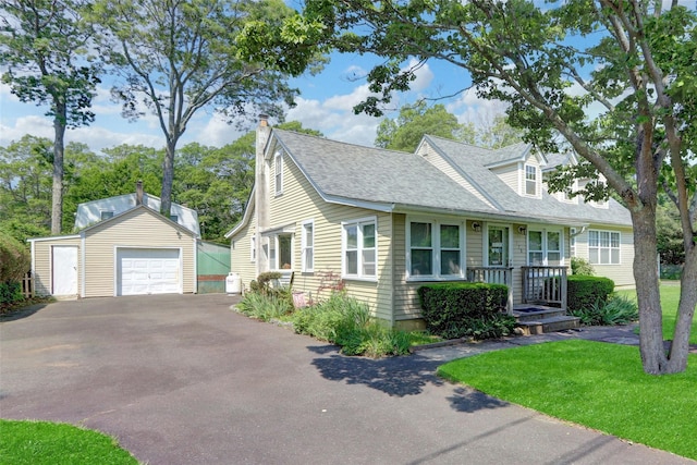 178 Magnolia Dr, Mastic Beach, NY 11951 - cape cod house featuring an outdoor structure, driveway, a detached garage, a shingled roof, and a chimney