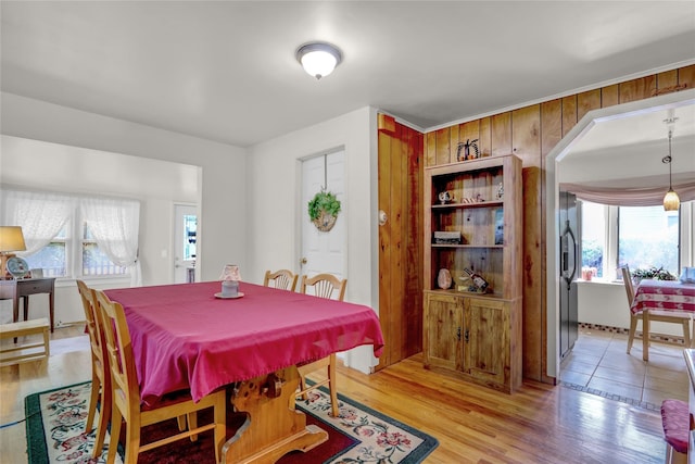 178 Magnolia Dr, Mastic Beach, NY 11951 - dining room with plenty of natural light, light wood-type flooring, wooden walls, and arched walkways