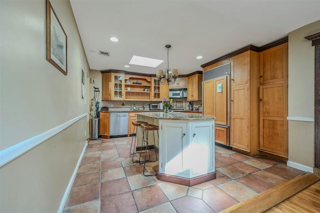 18 Huyler Ct, Setauket, NY 11733 - kitchen with appliances with stainless steel finishes, a chandelier, a kitchen island, a kitchen bar, and backsplash