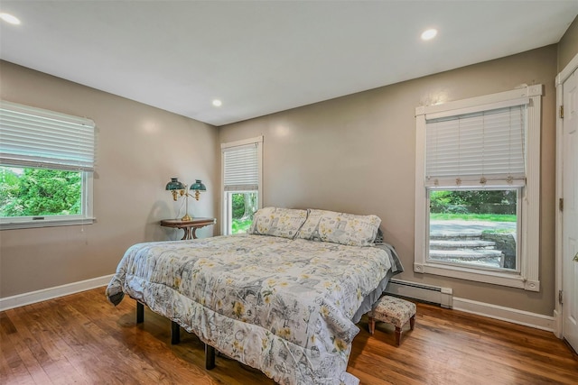 18 Huyler Ct, Setauket, NY 11733 - bedroom with a baseboard heating unit, multiple windows, wood finished floors, and recessed lighting
