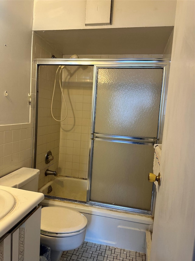 136-24 Maple Ave Unit 3B, Flushing, NY 11355 - full bath with vanity, shower / bath combination with glass door, tile walls, tile patterned floors, and a wainscoted wall