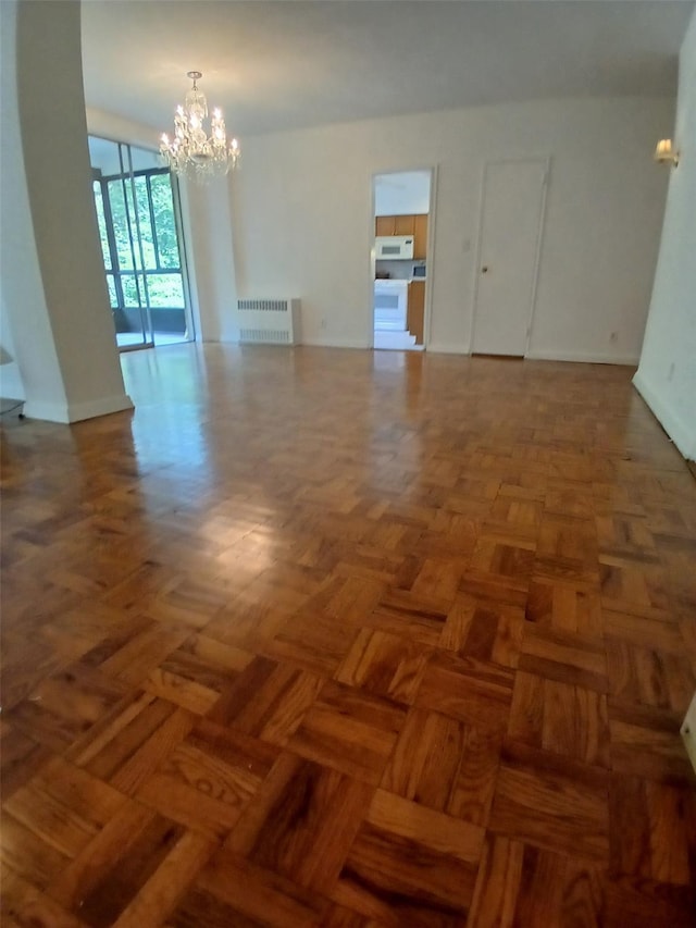 72 Pondfield Rd W Unit 2F, Bronxville, NY 10708 - spare room featuring radiator heating unit and a chandelier