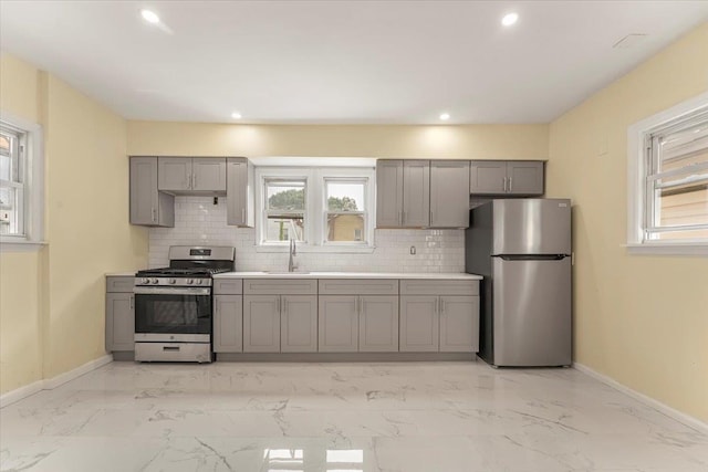 4216 Wickham Ave, Bronx, NY 10466 - kitchen featuring appliances with stainless steel finishes, gray cabinets, decorative backsplash, light marble finish floors, and recessed lighting