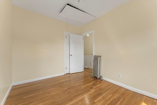 4216 Wickham Ave, Bronx, NY 10466 - empty room featuring attic access, light wood-style flooring, and radiator heating unit
