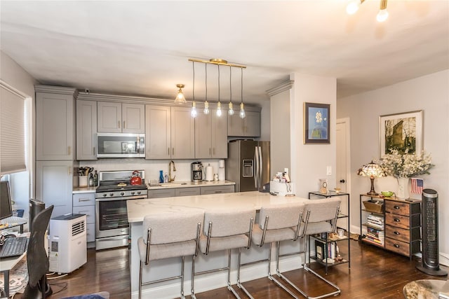 30-47 Hobart St Unit 6, Woodside, NY 11377 - kitchen with gray cabinetry, stainless steel appliances, light stone countertops, a breakfast bar, and dark wood-type flooring
