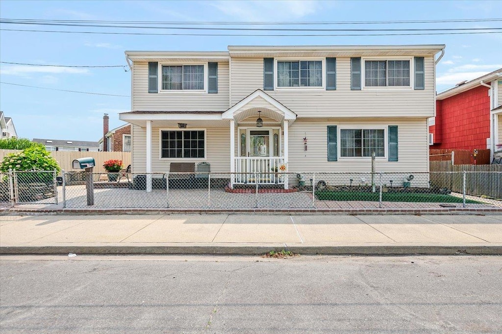 748 Knoll St, Lindenhurst, NY 11757 - view of front of house with covered porch and a fenced front yard