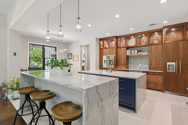 317 Old Mill Rd, Nissequogue, NY 11780 - kitchen with a spacious island, brown cabinets, recessed lighting, stainless steel oven, and light stone countertops