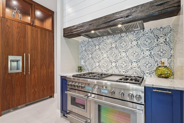317 Old Mill Rd, Nissequogue, NY 11780 - kitchen with range with two ovens, blue cabinets, decorative backsplash, light stone counters, and glass insert cabinets