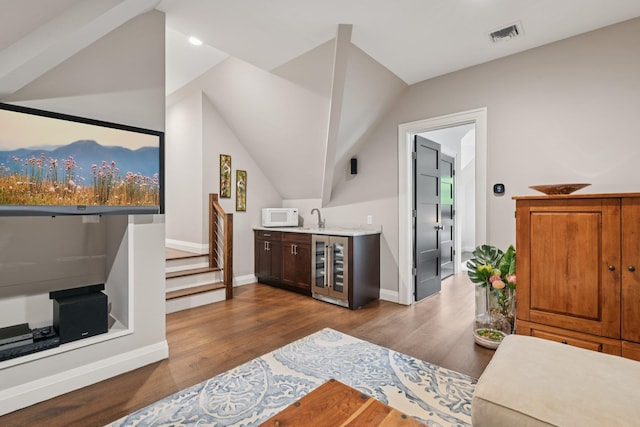 317 Old Mill Rd, Nissequogue, NY 11780 - indoor wet bar with white microwave, beverage cooler, wood finished floors, vaulted ceiling, and stairway