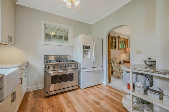 56 Locust Dr, Rocky Point, NY 11778 - kitchen with premium range, white fridge with ice dispenser, arched walkways, light wood-style floors, and ceiling fan