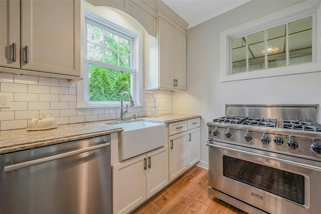56 Locust Dr, Rocky Point, NY 11778 - kitchen with appliances with stainless steel finishes, light wood-style floors, backsplash, light stone countertops, and white cabinets