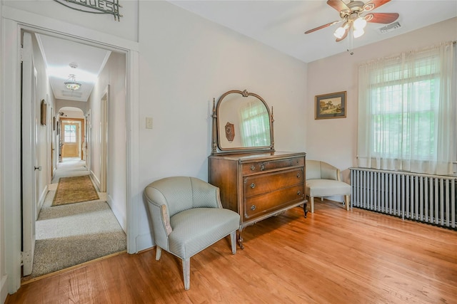56 Locust Dr, Rocky Point, NY 11778 - sitting room featuring ceiling fan, radiator heating unit, light wood-style flooring, and arched walkways