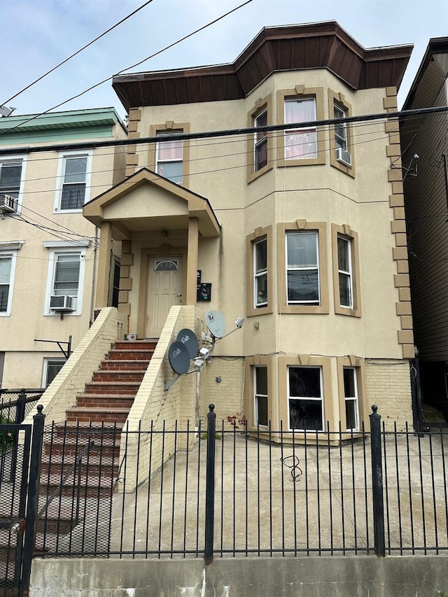 110 Beech St, Yonkers, NY 10701 - view of front facade with a fenced front yard and stucco siding