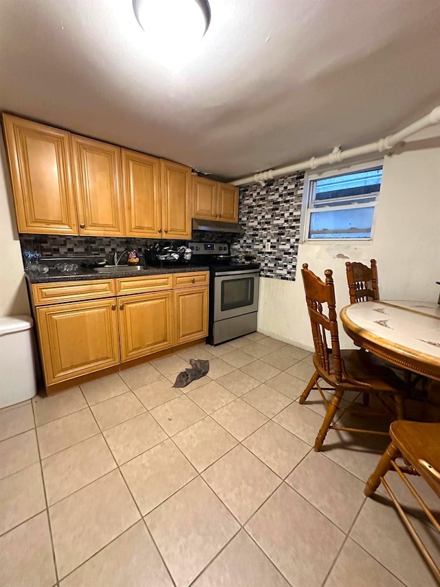 110 Beech St, Yonkers, NY 10701 - kitchen with stainless steel electric range oven, backsplash, dark countertops, under cabinet range hood, and light tile patterned flooring
