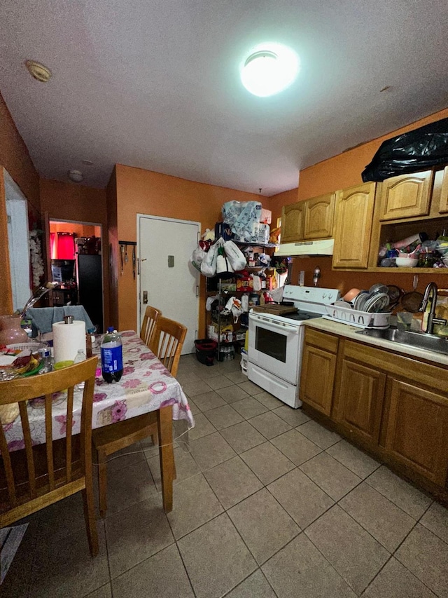 110 Beech St, Yonkers, NY 10701 - kitchen featuring electric range, under cabinet range hood, light tile patterned floors, and light countertops