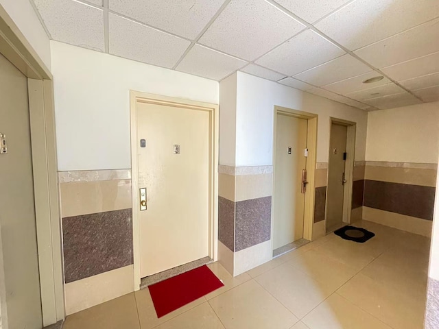 40-48 97th St Unit 1B, Corona, NY 11368 - corridor featuring a drop ceiling, a wainscoted wall, and tile patterned flooring