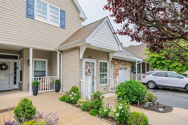 164 Ira Rd, Mount Sinai, NY 11766 - view of front facade with a porch, a garage, and roof with shingles