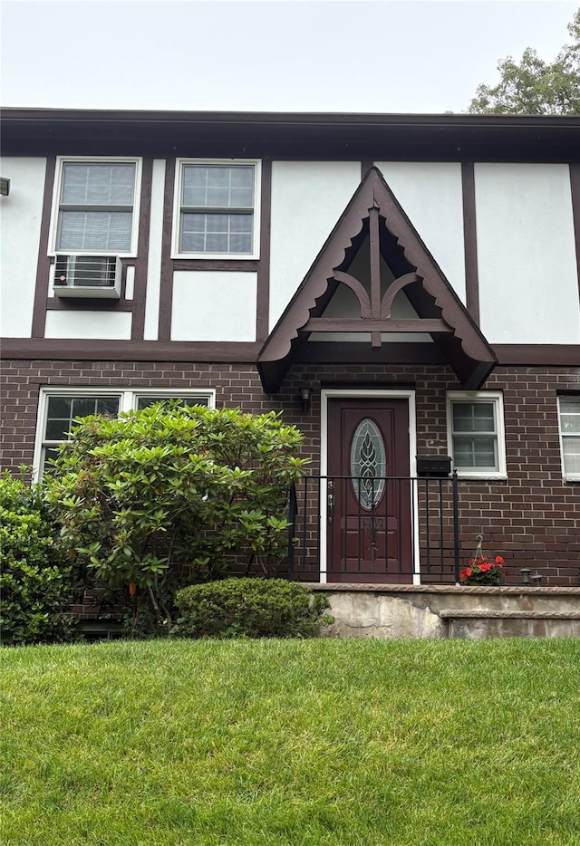 68 Yorkshire Dr, Suffern, NY 10901 - view of front of home with brick siding, a front lawn, cooling unit, and stucco siding