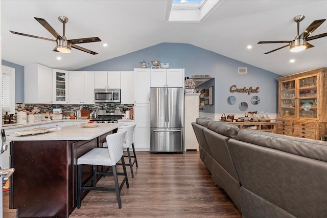 7 Pine Tree Dr, Shirley, NY 11967 - kitchen with appliances with stainless steel finishes, a ceiling fan, lofted ceiling, glass insert cabinets, and a kitchen island