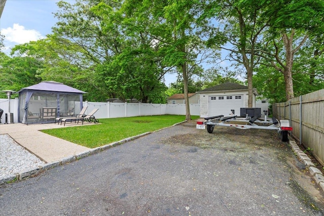 7 Pine Tree Dr, Shirley, NY 11967 - fenced yard featuring a gazebo, asphalt driveway, a garage, and an outbuilding