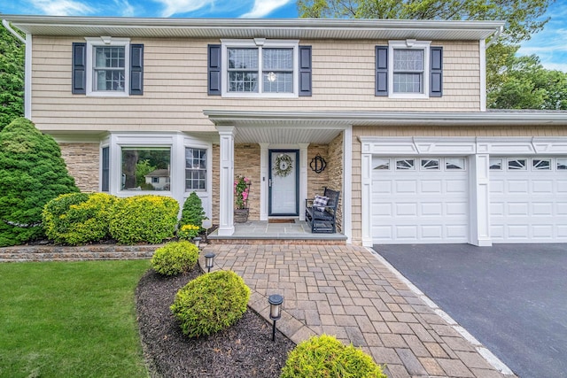 15 Format Ln, Smithtown, NY 11787 - view of front of house with driveway, a porch, stone siding, and a front lawn