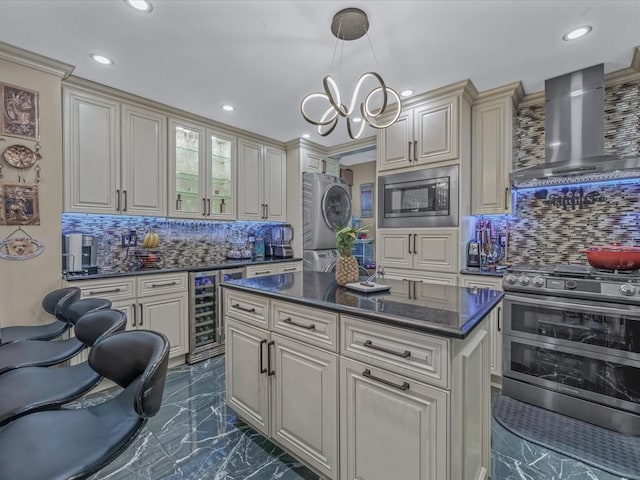11416 121st St, South Ozone Park, NY 11420 - kitchen with estacked washer and dryer, stainless steel appliances, wine cooler, wall chimney exhaust hood, and dark marble finish floors