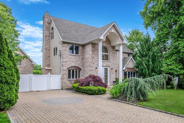53 Pequot Ln, East Islip, NY 11730 - view of front of home featuring a gate, a chimney, roof with shingles, and brick siding