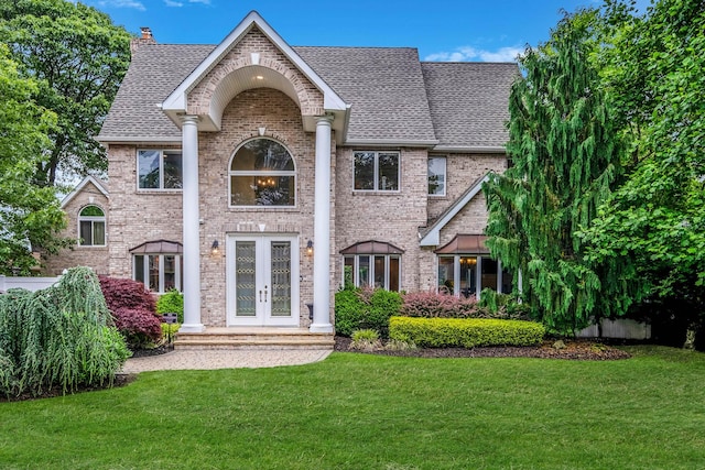 53 Pequot Ln, East Islip, NY 11730 - view of front of property with french doors, a shingled roof, a front yard, and brick siding