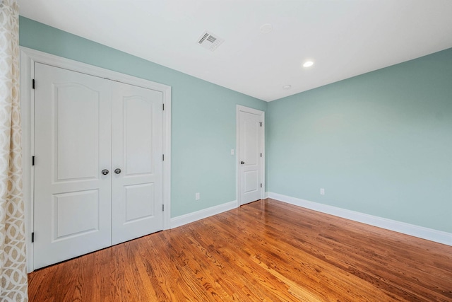 53 Pequot Ln, East Islip, NY 11730 - unfurnished bedroom with wood finished floors and recessed lighting