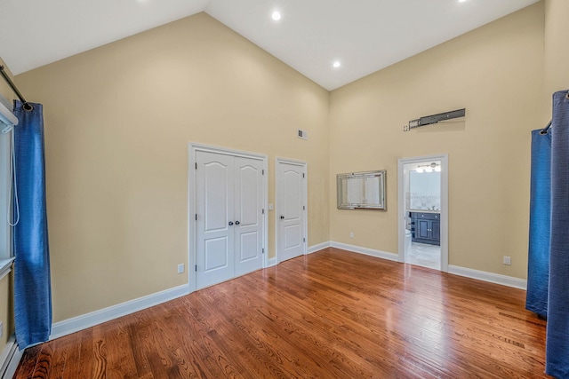 53 Pequot Ln, East Islip, NY 11730 - unfurnished bedroom featuring high vaulted ceiling, wood finished floors, ensuite bathroom, a baseboard radiator, and recessed lighting