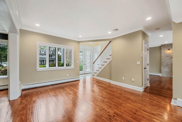 53 Pequot Ln, East Islip, NY 11730 - spare room with healthy amount of natural light, wood finished floors, crown molding, stairs, and a baseboard heating unit