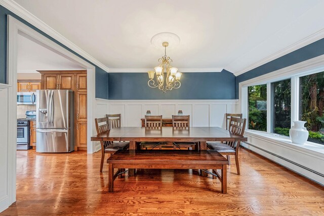 53 Pequot Ln, East Islip, NY 11730 - dining room featuring a chandelier, baseboard heating, ornamental molding, light wood finished floors, and wainscoting