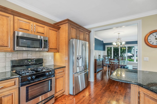 53 Pequot Ln, East Islip, NY 11730 - kitchen featuring appliances with stainless steel finishes, brown cabinets, a chandelier, wood finished floors, and tasteful backsplash