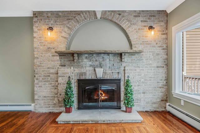 53 Pequot Ln, East Islip, NY 11730 - detailed view of baseboard heating, wood finished floors, a fireplace, and crown molding