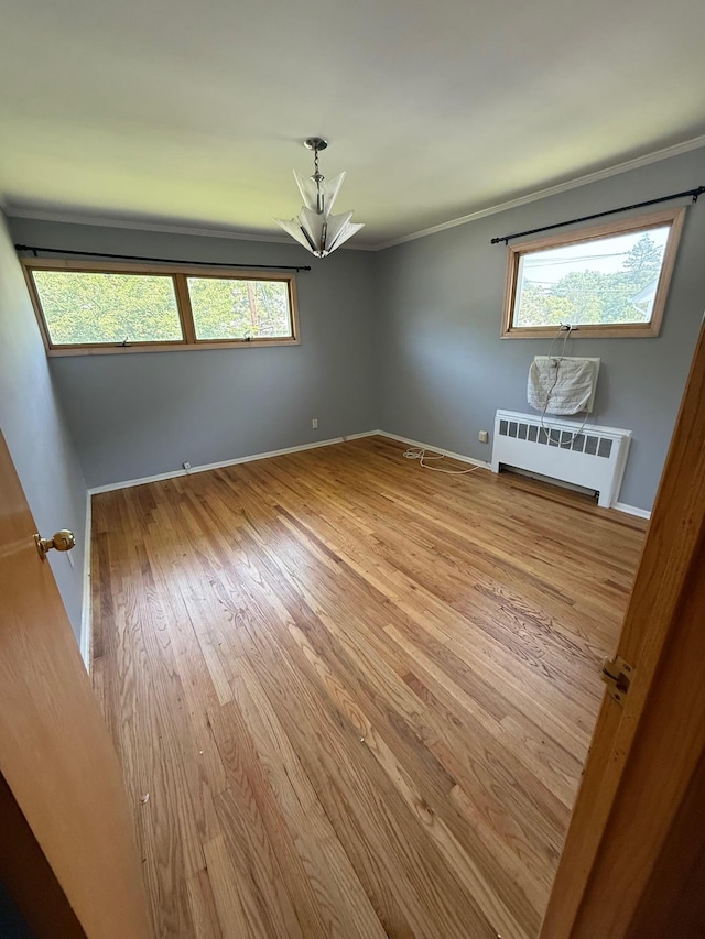 109 Nassau Dr, Albertson, NY 11507 - empty room featuring radiator, wood finished floors, ornamental molding, plenty of natural light, and a chandelier
