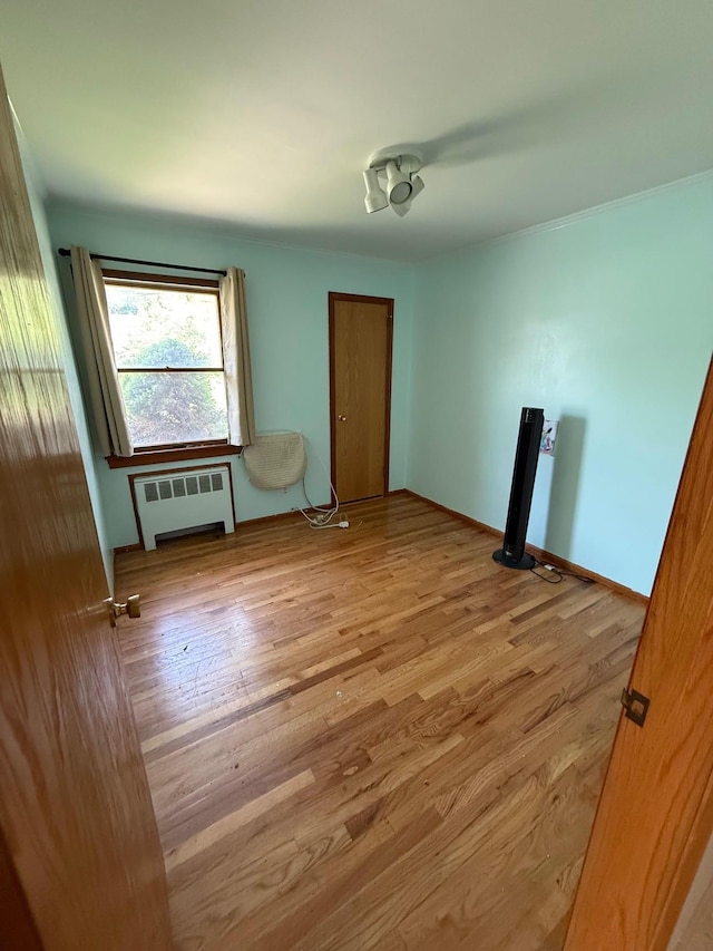 109 Nassau Dr, Albertson, NY 11507 - unfurnished bedroom featuring radiator heating unit, wood finished floors, and a closet