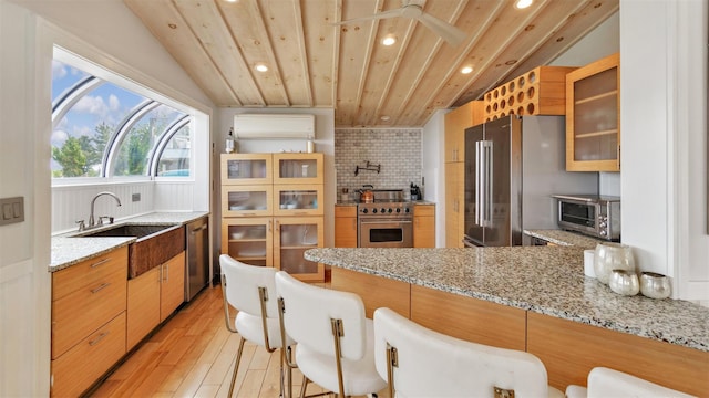 12910 Main Rd, East Marion, NY 11939 - kitchen featuring stainless steel appliances, recessed lighting, tasteful backsplash, light wood finished floors, and a peninsula