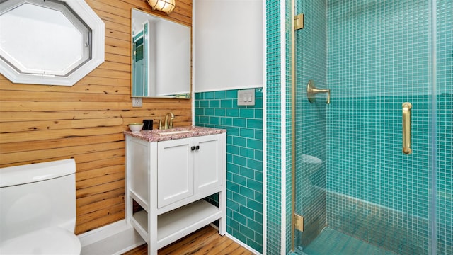 12910 Main Rd, East Marion, NY 11939 - full bath featuring vanity, a stall shower, tile walls, wood finished floors, and a wainscoted wall