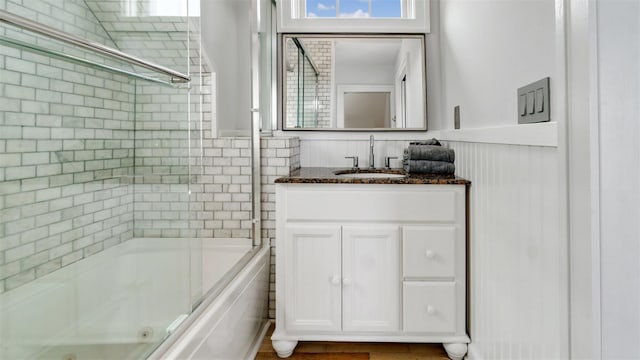 12910 Main Rd, East Marion, NY 11939 - full bath with a combined bath / shower with jetted tub, vanity, healthy amount of natural light, and wainscoting