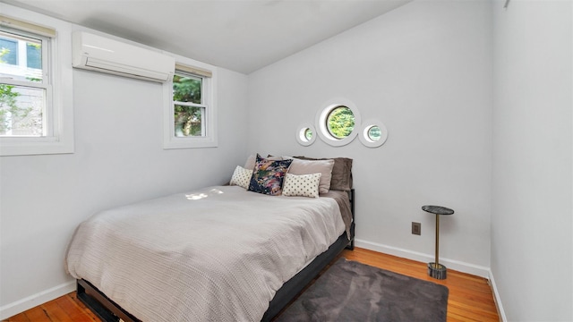 12910 Main Rd, East Marion, NY 11939 - bedroom with a wall unit AC, wood finished floors, and lofted ceiling