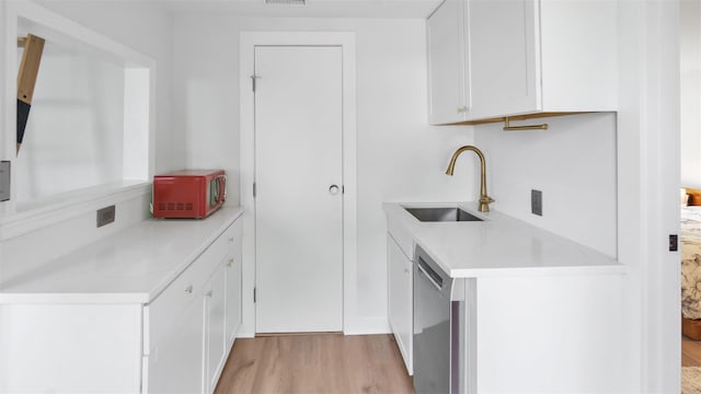 12910 Main Rd, East Marion, NY 11939 - kitchen featuring dishwasher, light wood finished floors, light countertops, and white cabinets