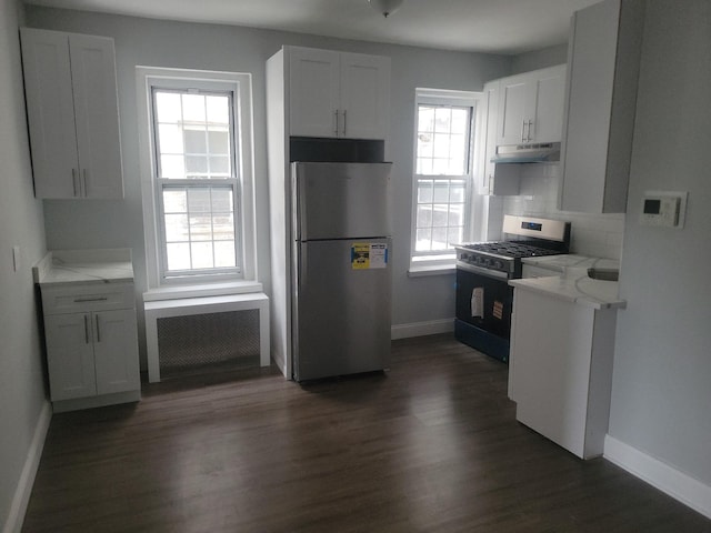 88-11 Elmhurst Ave Unit D15, Elmhurst, NY 11373 - kitchen featuring appliances with stainless steel finishes, under cabinet range hood, radiator heating unit, dark wood-style flooring, and tasteful backsplash