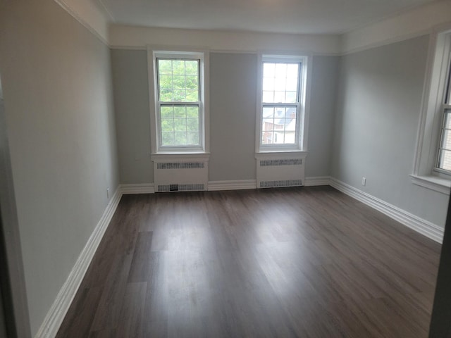 88-11 Elmhurst Ave Unit D15, Elmhurst, NY 11373 - unfurnished room featuring radiator heating unit, plenty of natural light, and dark wood finished floors