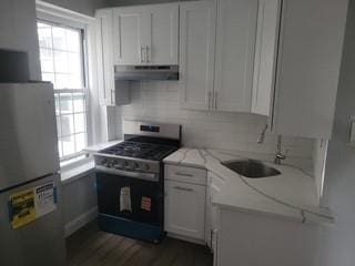 88-11 Elmhurst Ave Unit D15, Elmhurst, NY 11373 - kitchen featuring freestanding refrigerator, gas stove, under cabinet range hood, and plenty of natural light